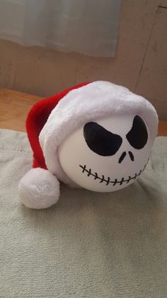 a stuffed toy with a santa hat on it's head sitting on a bed