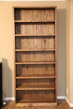 an empty bookcase in the corner of a room