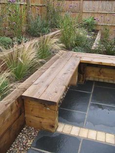 a wooden bench sitting in the middle of a garden