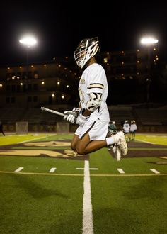 a lacrosse player is jumping in the air