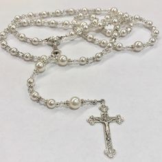 Create a custom rosary that will be cherished for years to come. A perfect gift for First Communion, Baptism, Weddings, and Birthdays. Send me a message with the color combinations that you would like before placing your order. D E T A I L S MATERIAL: Swarovski beads / Silver Plated / Pewter CRUCIFIX SIZE: Varies LENGTH: Varies I N C L U D E S * Kraft jewelry box with grosgrain ribbon * Blank card to write a personal note (optional) G I F T ∙ W R A P ∙ A V A I L A B L E * Wrapped in Kraft paper Personalized Silver Rosary For Confirmation, Handmade Silver Wedding Rosary, Handmade Silver Rosary For Baptism, White Spiritual Rosary For Anniversary, Personalized Silver Rosary For First Communion, Wedding Rosary With 8mm Beads Cross, Handmade Wedding Rosary With Cross Shape, Communion Gifts Girl, Custom Rosary