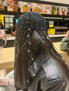 the back of a woman's head with braids on it at a restaurant