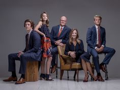 a group of people in suits and ties are posing for a photo on a chair