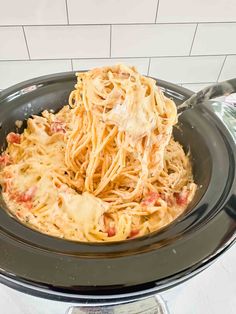 a plate of spaghetti with meat and cheese on it is being held up by a fork