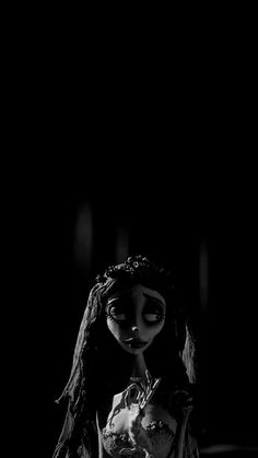 a doll with long hair standing in the dark