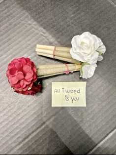 two fake flowers are sitting next to a note that says, all i need is you