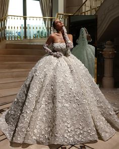 a woman in a wedding dress standing on stairs