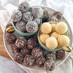 two bowls filled with chocolate covered donuts next to other desserts on a white plate