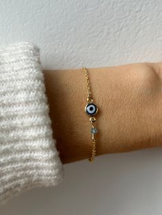 Brush away negative energy and jealous prying eyes with this dainty evil eye bracelet that you can customise by adding the gemstone/birthstone of your choice. D E T A I L S *It features a gold filled evil eye charm (12 x 6.5mm) in traditional blue *on an 18k gold filled chain in yellow gold.  *Gold fill or gold filled is an amazing quality alternative to solid gold. Unlike gold plating that over time tends to tarnish, gold filled is an actual layer of gold, pressure- bonded to another metal and with the proper care can last for years. *Add the gemstone of your choice. These are high quality crystals measuring between 3 and 4mm.  *Length: Choose the length you prefer from the drop down menu. A snug fit works best for the bracelet so use the length chart as a reference. *Bracelet comes with Minimalist Evil Eye Bracelet With Adjustable Chain As Gift, Dainty Evil Eye Bracelet Jewelry, Dainty Adjustable Evil Eye Bracelet, Minimalist Beaded Bracelet With Evil Eye For Gift, Minimalist Evil Eye Beaded Bracelets As Gift, Minimalist Evil Eye Bracelet For Gift, Minimalist Evil Eye Bracelet As Gift, Dainty Evil Eye Bracelet With Adjustable Chain, Minimalist Round Evil Eye Bracelet