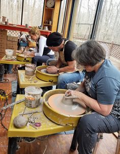 several people working on pottery in a workshop