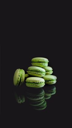 a stack of green macaroons sitting next to each other on a black surface