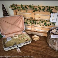 an open suitcase sitting on top of a wooden table next to shells and other items