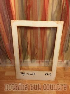 an old photo frame sitting on the floor in front of a curtained wall with words nothing but country written below it