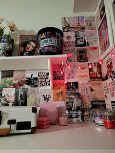 a white shelf topped with lots of pictures and posters