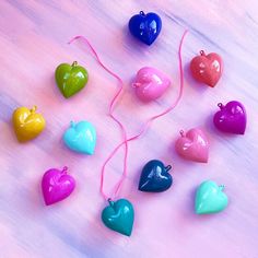 several heart shaped ornaments on a pink table with string attached to the top and two strings hanging from them