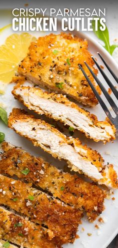 crispy parmesan chicken cutlets on a plate with lemon wedges and garnish