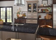 a kitchen with black granite counter tops and wooden cabinets, along with an island in the middle