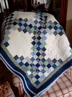 a blue and white quilt sitting on top of a chair