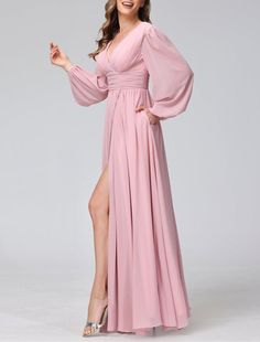 a woman wearing a pink dress with long sleeves and thigh slits, posing for the camera