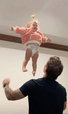 a man holding a baby up in the air