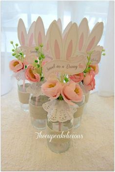 small vases filled with flowers on top of a white carpeted floor and a sign that says sweet as a bunny