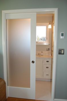 an open door leading to a bathroom with a sink and mirror on the opposite wall