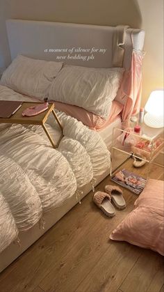 a bed with white comforters and pink pillows