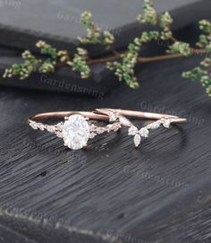 two rose gold wedding rings with diamonds on top and green leaves in the back ground