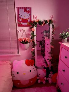 a hello kitty bedroom with pink walls and flowers on the dresser, bedding and mirror