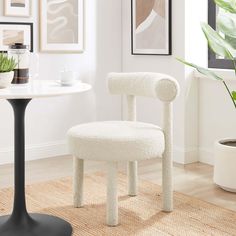 a white chair sitting on top of a rug next to a table