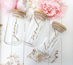 three personalized mason jars sitting next to a pink flower