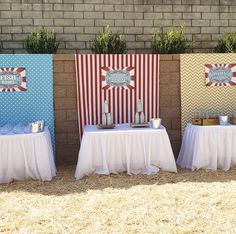 three tables are set up in front of a brick wall and decorated with red, white and blue decorations