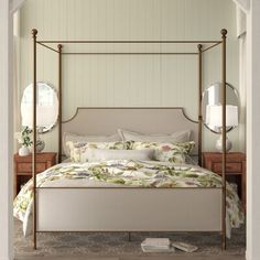 a bedroom with a four poster bed and mirror on the wall next to two nightstands