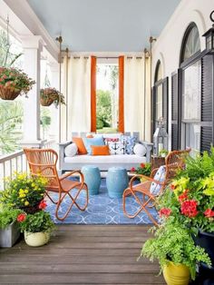 the porch is decorated with colorful flowers and chairs