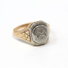 Lovely antique dated 1927 Art Deco era 14k yellow and white gold signet ring! This stylish statement ring is is adorned with floral designs on each shoulder. The ring face reads Minneapolis High School with a school emblem on the front. The inside of the ring band is sweetly engraved 'L.E.J. - 27.' A fantastic piece of fine Art Deco era dated jewelry! *Sale - price reduced from $425 USD to $395 USD.  ERA - Dated 1927 - Art Deco  METAL / MATERIAL - 14k yellow & white gold MARKINGS / HISTORY - Ins School Emblem, Art Deco Metal, The Ring Face, Logo Gifts, Gold Signet Ring, Art Deco Era, White Gold Band, Flower Jewelry, Flower Jewellery