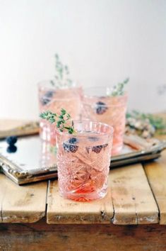 a wooden table topped with glasses filled with drinks