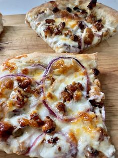 two slices of pizza sitting on top of a wooden cutting board next to each other