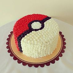 a cake with white and red frosting sitting on top of a table