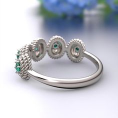 a close up view of a ring on a table with blue flowers in the background