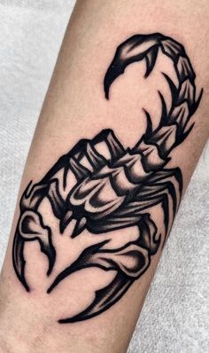 a black and white scorpion tattoo on the arm