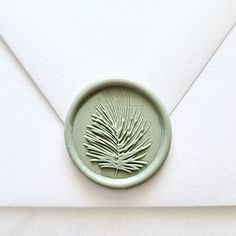 an envelope with a wax stamp and a pine tree in the center on it's front