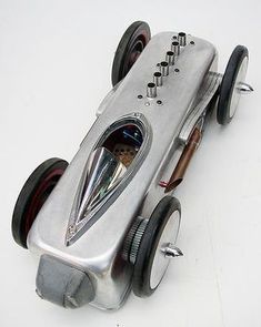 a silver toy race car sitting on top of a white table