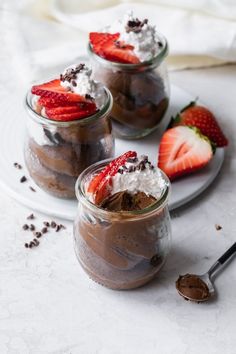 three dessert jars with chocolate pudding and strawberries