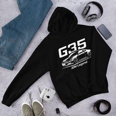 Hoodie inspired by the legendary V35 G35 Coupe. We like to bring the best automotive apparel gifts for car guys with totally unique designs and illustrations inspired by the cars of your dreams. The illustration featured on this hoodie is a digital artwork inspired by automotive culture that will be sold in limited copies. * 50% pre-shrunk cotton, 50% polyester * Fabric weight: 8.0 oz/yd² (271.25 g/m²) * Air-jet spun yarn with a soft feel and reduced pilling * Double-lined hood with matching drawcord * Quarter-turned body to avoid crease down the middle * 1 × 1 athletic rib-knit cuffs and waistband with spandex * Front pouch pocket * Double-needle stitched collar, shoulders, armholes, cuffs, and hem * Blank product sourced from Honduras, Mexico, or Nicaragua Gifts For Car Guys, G37 Coupe, G35 Coupe, Automotive Apparel, Bandana Styles, Cozy Hoodie, Car Guys, Comfy Hoodies, Knit Cuff