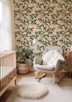 a baby's room with an orange tree wallpaper and rocking chair in the foreground