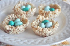 rice krispy treats with blue eggs are on a white plate