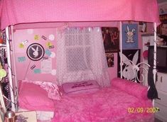 a pink bed with white curtains and polka dots on the sheets, in a bedroom