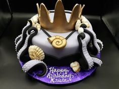 a birthday cake decorated with seashells, pearls and a crown for a king