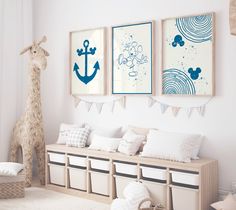 there are three pictures hanging on the wall in this child's room, and one has an anchor