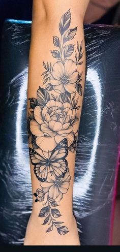 a woman's leg with flowers and butterflies tattoo on the side of her body